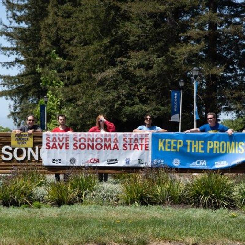 5 people hold up 3 signs.  Sign one is We Make  American Work.  Sign two is Save Sonoma State, sign three is Keep the promise.