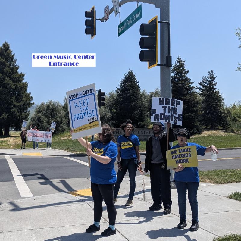 Green Music CEnter Entrance  people stand in front holding signs.  Stop the cuts, Keep the Promise. and We make American Work